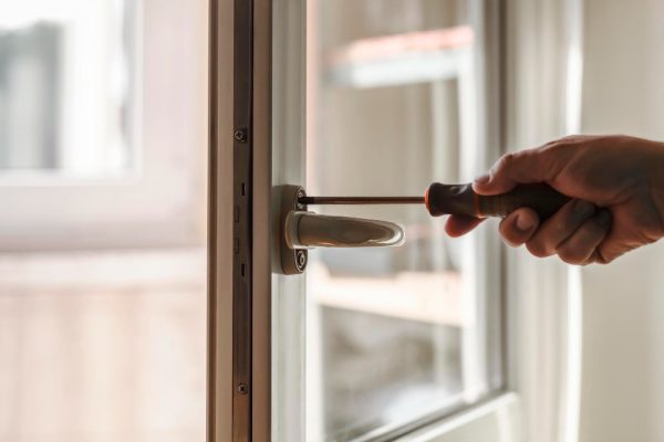 installation-window-handle-handyman-installing-lock-front-plastic-door-with-screwdriver